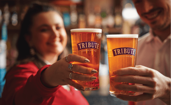 Two rugby fans raise pints of Tribute
